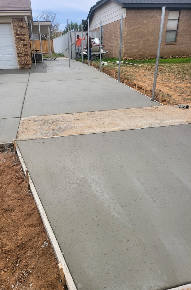 New driveway extension poured alongside a brick home in Lubbock